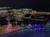 An elevated nighttime view of a festive area with illuminated decorations and a cityscape in the background.