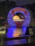 The image features a brightly lit, festive archway adorned with colorful Christmas lights, reading