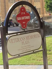 The image shows a sign for the Veterans Memorial Plaza located in the City of San Antonio, Texas, with the address 415 Jefferson.