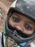 Three people wearing helmets are taking a selfie while on an ATV adventure through a woodland trail.