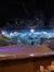 The image shows an indoor arena with a winter-themed stage backdrop decorated with snowy houses and a starry night sky.