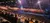 The image shows a large arena packed with spectators watching a horse and rider perform under stage lights.