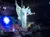An angelic figure in a stage production is suspended mid-air with a mystical background and dramatic lighting.