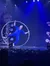 A performer in a blue outfit is skillfully balancing inside a large hoop on a stage decorated with a North Pole theme.