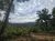 A scenic view of a lush green forested landscape under a cloudy sky.