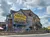 The image shows a rustic building with large signs reading 