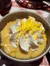A bowl of pudding topped with white whipped cream and yellow sprinkles.