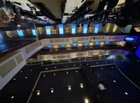 The image depicts an upside-down view of a theater or auditorium with rows of seats, balconies, and a stage.