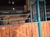 A horse is standing inside a wooden and metal enclosure, partially obscured by the gate.