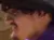Two people wearing cowboy hats are sitting on a horse-drawn wagon inside an arena with sandy ground.