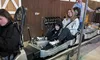 A family is sitting in an alpine coaster cart, ready for a ride indoors.