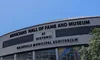The image shows the Musicians Hall of Fame and Museum at the historic Nashville Municipal Auditorium under a clear blue sky, with a sign displaying the date April 16.