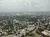 Aerial view of a sprawling urban landscape seen through a rain-speckled window.