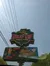 The image displays a roadside sign for the