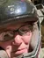 A group of people wearing helmets enjoy riding ATVs on a wooded trail.