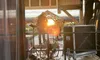 The image shows a wooden outdoor stage setup with a person adjusting equipment, a 