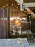 The image shows a wooden outdoor stage setup with a person adjusting equipment, a 