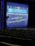 The image shows a theater stage with a sign displaying