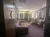 The image shows a warmly lit room with a purple sofa, striped chairs, walls decorated with framed artwork, and mirrors with lights, resembling a luxurious dressing or lounge area.