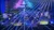 A vibrant stage show featuring a performer surrounded by colorful lasers and lights creating dynamic patterns.