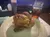 A whole roasted chicken is served on a plate alongside a mason jar filled with a fizzy drink.