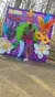 A couple is happily embracing in front of a vibrant Mardi Gras-themed photo spot at Busch Gardens.