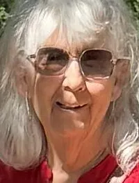 Two people stand under a decorative sign reading 