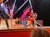 A lively stage performance features a couple dancing energetically, with musicians playing in the background and starry decorations enhancing the atmosphere.