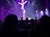 An acrobat performs a balancing act on stage with spotlights and an audience watching.
