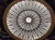 The image shows an ornate, symmetrical glass dome ceiling with intricate patterns and a central light fixture.