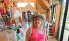 A person in a pink top and cowboy hat stands inside a store next to a large decorative cow statue.
