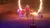 A performer is riding a horse through a flaming hoop in an arena setting.
