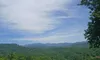 A scenic view of lush green hills under a partly cloudy sky.