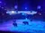 The image shows an arena with several bison on a sandy floor, surrounded by a blue-lit stage with a scenic backdrop of a sunset and teepees.
