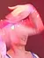 Performers in colorful costumes are energetically dancing on a stage under red lighting.