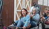 A young girl and an older woman are sitting together in a sled-like ride at an amusement park.