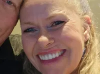 A smiling couple is posing closely for a selfie indoors.