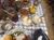 A table is set with a meal of fried chicken, mashed potatoes, coleslaw, corn, and drinks, with a person using a fork on the food.