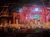 A group of performers on stage is entertaining an audience in a theatrical setting resembling a rustic barn.