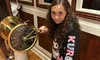 A young girl is standing next to a ship's engine order telegraph, playfully holding the handle.