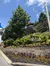 The image shows a landscaped area with a sign that reads