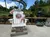 A person is sitting on a large Adirondack chair in front of a mountain coaster attraction.