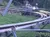 A person is riding a small roller coaster or alpine slide on a metal track surrounded by greenery.