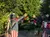 Two bear statues dressed in American flag attire are high-fiving each other in a garden setting.
