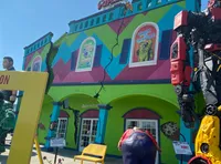 The image depicts a colorful Ripley's Believe It or Not! building with quirky decorations, such as a giant robot and a humorous sculpture of a person with an oversized rear end.