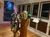 The image shows a nautical-themed interior with a ship's wheel and compass, along with a portrait and various framed pictures on the walls.