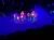 The image shows a vibrant, illuminated display of colorful flowers with a misty blue backdrop, creating a magical atmosphere.
