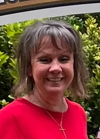 Three people are posing in front of the 