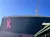 The image shows a large structure resembling the Titanic ship with a prominent pink ribbon on its side, set against a clear blue sky.