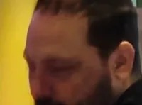 The image shows the interior of a theater with people dining below a multi-level balcony, and a stage area on the left with a sign reading 